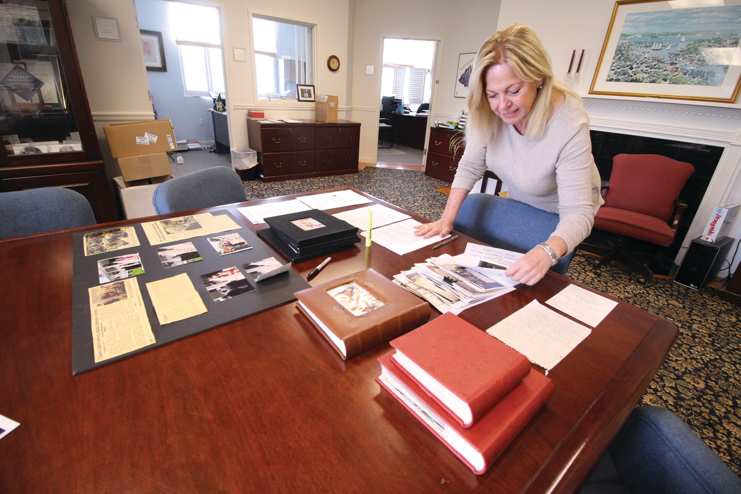 SO MANY ACHIEVEMENTS: Judith Earle, director of the Elizabeth Buffum Chace Center looks over photographs, newspaper clippings and letters documenting the history of the center founded 40 years ago.